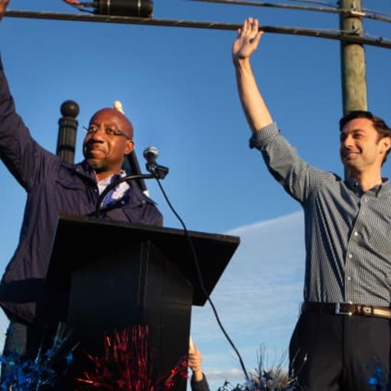 Democratic U.S. Senate candidates Jon Ossoff (R) and Raphael Warnock (L) of Georgia wave to supporters during a rally on November 15, 2020 in Marietta, Georgia. Jessica McGowan | Getty Images