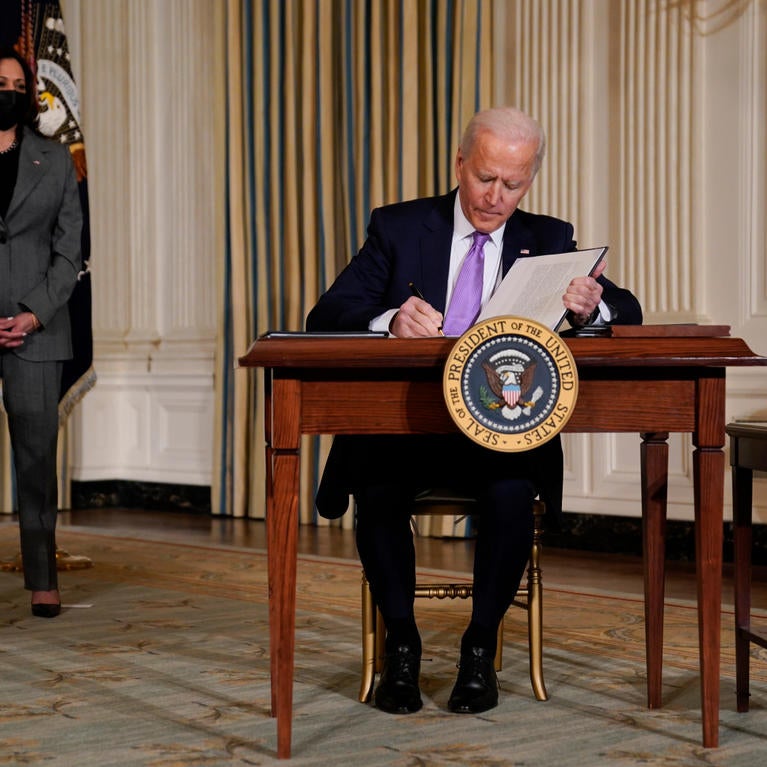 President Joe Biden signs executive orders on racial equity in the State Dining Room of the White House, Tuesday, Jan. 26, 2021, in Washington. Vice President Kamala Harris listens at left. (AP Photo/Evan Vucci)