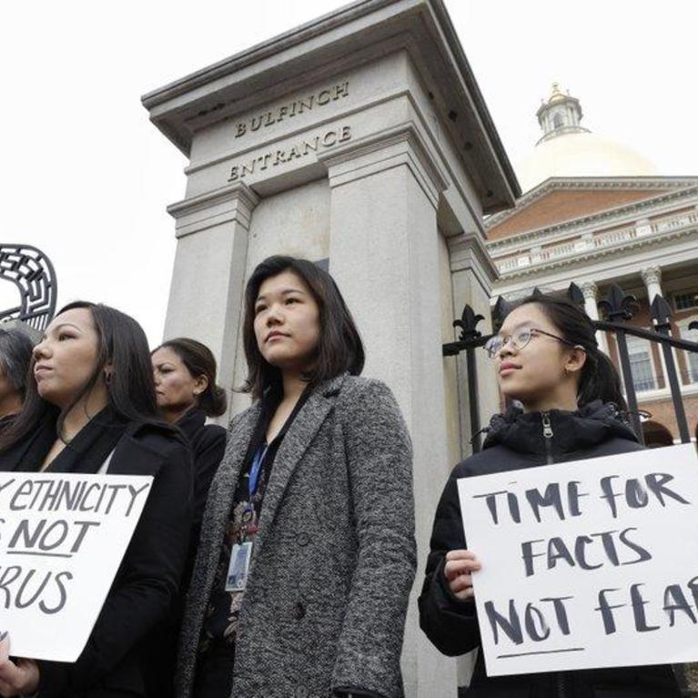 Jessica Wong, of Fall River, Mass., front left, Jenny Chiang, of Medford, Mass., center, and Sheila Vo, of Boston, from the state's Asian American Commission, stand together during a protest. ( AP Photo/Steven Senne )