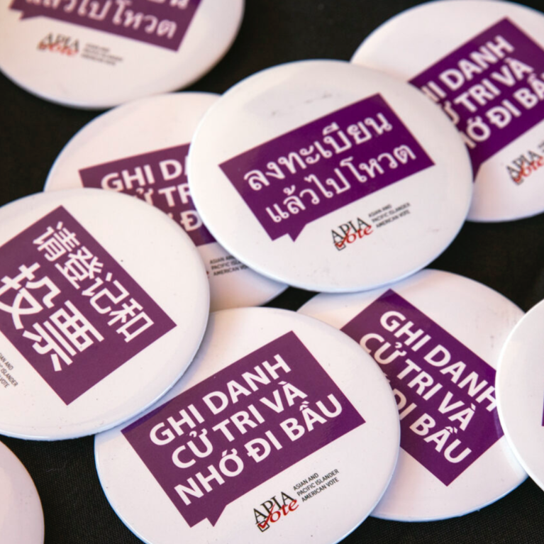 "Register to vote" buttons in eight languages are seen during the Asian American and Pacific Islander Puppies and Boba event in Las Vegas on Saturday, Oct. 24, 2020. (Jeff Scheid/The Nevada Independent)
