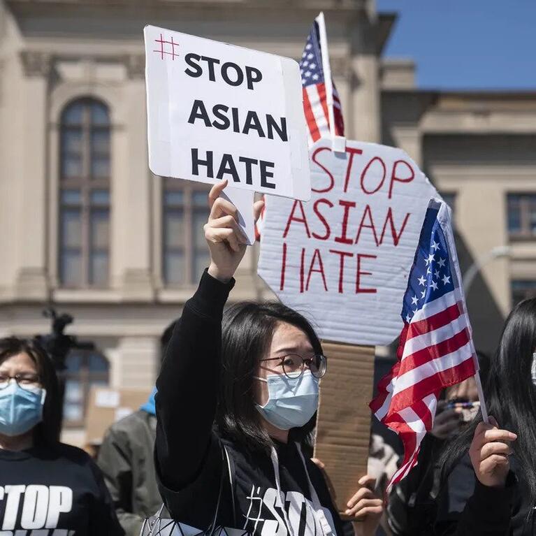 Demonstrators hold signs during a Stop AAPI Hate Rally outside the State Capitol on March 20, 2021.