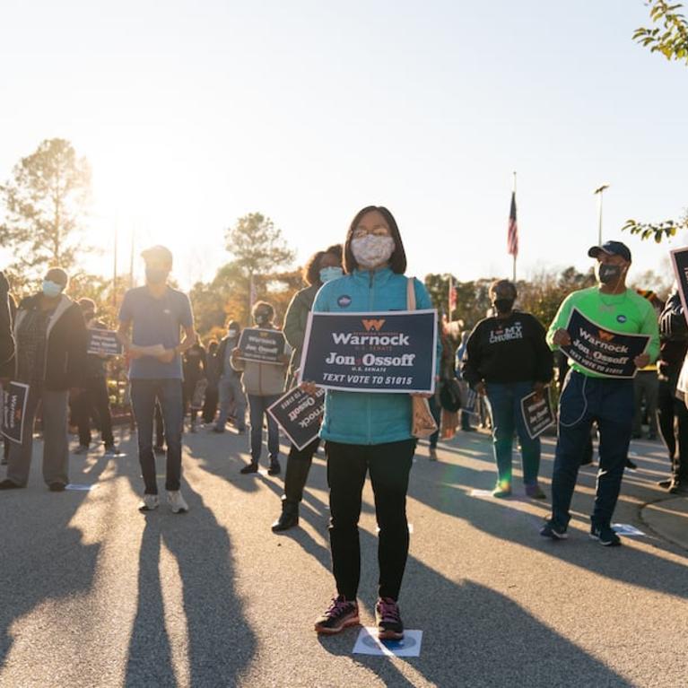 Socially distanced supporters attend a rally for Democratic U.S. Senate candidates Raphael Warnock and Jon Ossoff on Nov. 19 in Jonesboro, Ga. The two will face off against Sens. Kelly Loeffler and David Perdue, respectively, in the state’s Jan. 5 runoff. (Elijah Nouvelage/Getty Images)