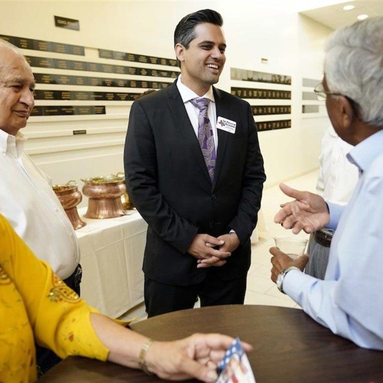 Democrat for Congress candidate Sri Kulkarni, center, listens to supporters attending a fundraiser for him in Houston. Kulkarni is running against Republican U.S. Rep. Pete Olson.