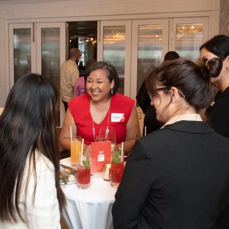 Margaret Huang, president and CEO of the Southern Poverty Law Center, talks with members of the Asian American Journalists Association (AAJA) during a social gathering June 28, 2022, in Washington, D.C.