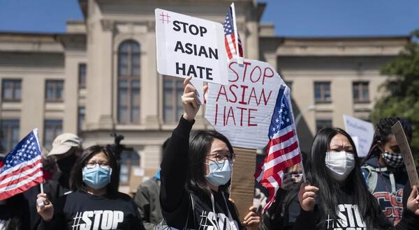 Demonstrators hold signs during a Stop AAPI Hate Rally outside the State Capitol on March 20, 2021.