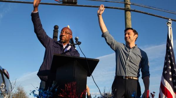 Democratic U.S. Senate candidates Jon Ossoff (R) and Raphael Warnock (L) of Georgia wave to supporters during a rally on November 15, 2020 in Marietta, Georgia. Jessica McGowan | Getty Images