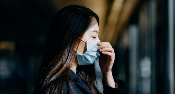 Image of woman wearing mask looking distraught