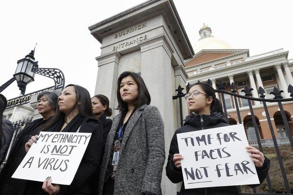 Jessica Wong, of Fall River, Mass., front left, Jenny Chiang, of Medford, Mass., center, and Sheila Vo, of Boston, from the state's Asian American Commission, stand together during a protest. ( AP Photo/Steven Senne )