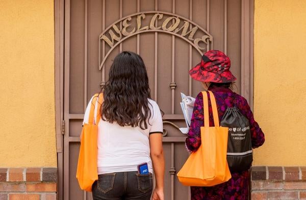 Census workers and local nonprofits are pivoting and scrambling to use phone banks, texting and online tools to fill gaps in outreach efforts. Above, Wendy Barillas, left, and community census educator Lazara Bustos with the nonprofit Give for a Smile wait for a resident to answer the door in Anaheim on Wednesday, March 11, 2020 as part of a door-to-door effort to encourage residents to participate in the census. (Photo by Leonard Ortiz, Orange County Register/SCNG)