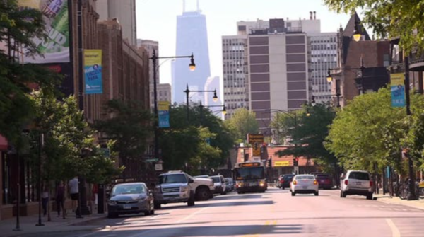 Image of a city with vehicles on the road and a city skyline in the background 