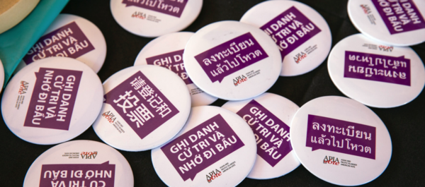 "Register to vote" buttons in eight languages are seen during the Asian American and Pacific Islander Puppies and Boba event in Las Vegas on Saturday, Oct. 24, 2020. (Jeff Scheid/The Nevada Independent)