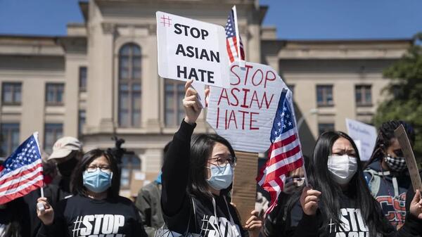 Demonstrators hold signs during a Stop AAPI Hate Rally outside the State Capitol on March 20, 2021.