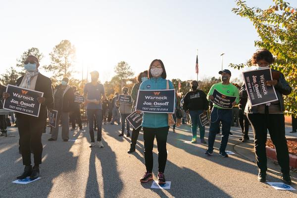 Socially distanced supporters attend a rally for Democratic U.S. Senate candidates Raphael Warnock and Jon Ossoff on Nov. 19 in Jonesboro, Ga. The two will face off against Sens. Kelly Loeffler and David Perdue, respectively, in the state’s Jan. 5 runoff. (Elijah Nouvelage/Getty Images)