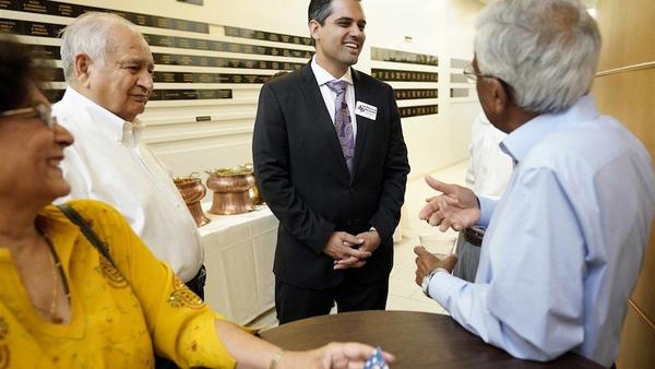 Democrat for Congress candidate Sri Kulkarni, center, listens to supporters attending a fundraiser for him in Houston. Kulkarni is running against Republican U.S. Rep. Pete Olson.